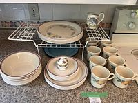 Overall view of dinnerware set on counter with rack