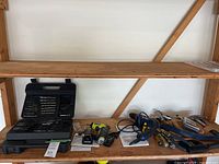 Shelf with drill bit set, drills, hand tools visible