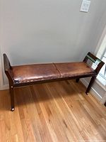 Full view of wood bench against wall on hardwood floor