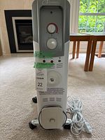 Front view of Garrison oil-filled heater on wheels with extension cord coiled at base