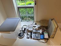 Overview showing calculator, power strip, wireless charger, cables, speakers, file holder, storage bin