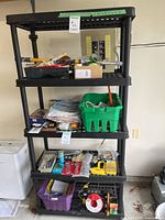 Full view of black plastic five-tier shelving with assorted contents (not included)