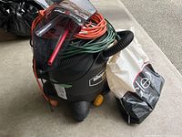 ToolMate shop vacuum with extension cords, VacuFlex kit and plastic bag of accessories