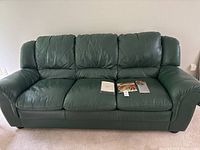Front view of green leather Natuzzi three-seat sofa