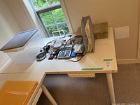 Overall view of L-shaped white desk from above, contents on top not included