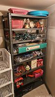 Full view of gray metal shelving unit loaded with various items to show overall condition and size.