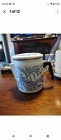 Blue Willow enamelware coffee pot with blue landscape pattern and lid on