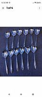 Top view of 12 spoons including 6 round soup spoons showing the full handles and bowls