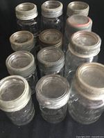 12 Canadian Jewel vintage glass canning jars displayed, 6 large and 6 medium size, with metal lids showing wear