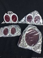Four oval pewter floral picture frames, three are double oval 2.5 x 3 inch size and one is single oval 5 x 7 inch size, all brand new in packaging