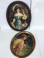 View of two oval metal trays with vintage Coca-Cola and Pepsi-Cola advertising art.