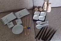 Full set of Japanese dinnerware including bowls, soy sauce dishes, soup spoons, sake bottles and cups, and multiple chopsticks