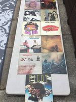 Photo showing all 11 vinyl LP records laid out on a table, displaying the album cover artwork and wear.