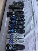 Photo of 13 assorted universal and TV remotes showing various brands and colors, including multiple Bell remotes.