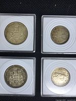 Top view of all four coins in protective holders showing obverse and reverse sides.