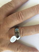 Ring shown worn on finger with visible size 12.5 label and detailed Celtic pattern on band.