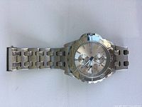Men's Guess wristwatch showing full metal bracelet and face of watch.