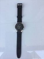 Full view of the wristwatch with rubber band and metal case.