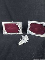 Two pewter photo frames with sea life designs and a dolphin-shaped hook