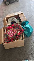 Two boxes with assorted Christmas decorations and turquoise bag