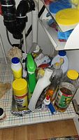 Tray of various cleaning products under sink