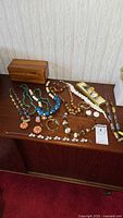 Overview of all jewelry pieces, pocket watch, and Lane cedar box displayed on surface