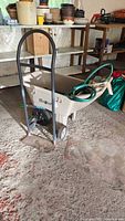 Overall view of Ames Easy Roller cart with hose and Milwaukee hand truck