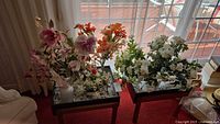 Both faux floral arrangements on separate tables