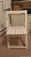 Front view of white wooden folding chair with slatted seat