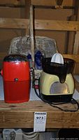 Front view showing red Ice-O-Mat ice crusher, cream electric juicer, wicker basket