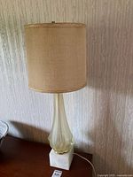 Full view of lamp with shade, glass body, marble base on table