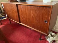 Front view showing sliding doors, legs, pulls