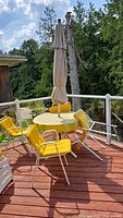 Set on deck showing table, four chairs, umbrella