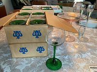 Boxed Luminarc green stem goblets with additional pink coupes and clear cordials on table