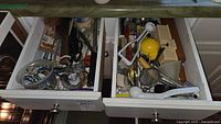 Two kitchen drawers filled with assorted utensils and gadgets