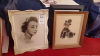 Both framed pieces side by side: portrait photograph and poodle drawing
