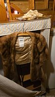 Brown fur stole on hanger with lace pieces above