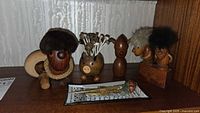 Group of wooden figures, pig holder, acorn man, small pair, stopper, and tray on shelf