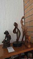 Group shot of four wood sculptures on shelf