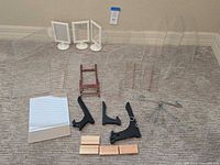 Full lot arranged on floor showing various clear acrylic display stands of different sizes along with white picture holders, wooden blocks, black wooden holders, metal display tree, and small mirror stand.