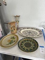 Photo shows antique Art Nouveau enameled glass vase, Roseville Wild Rose pitcher, and three decorative plates arranged on a table.