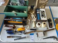 Top-down view of the entire lot on table, showing toolkit box, various hand tools, and accessories.