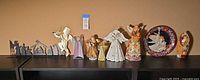 Wide shot of all items showing angels, nativity silhouette, decorative plate, and various religious figurines.