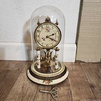 Overview of the German 400 day anniversary clock under glass dome with floral face and base.