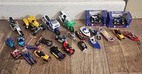 Photo shows a collection of diecast motorcycles, ATVs, snowmobiles, jet boats, and other toy vehicles arranged on a wooden floor. Includes boxed Yamaha motorcycles in the back.