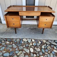 Front view of desk showing floating top and dual pedestal drawers