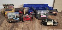 Full overview of lot items including Japanese tin police car, Hot Wheels trailer, and Matchbox collectible cars in boxes and display cases.