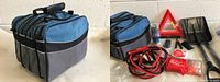 Blue/grey bag with compartments and all emergency items displayed showing the booster cables, shovel, triangle sign, and first aid kit.