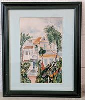 Frontal view of framed painting showing planter's mansion and lush palm trees with vibrant foliage.