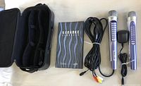 Two silver-purple microphones, IR receiver, AV cable, karaoke manual and black case